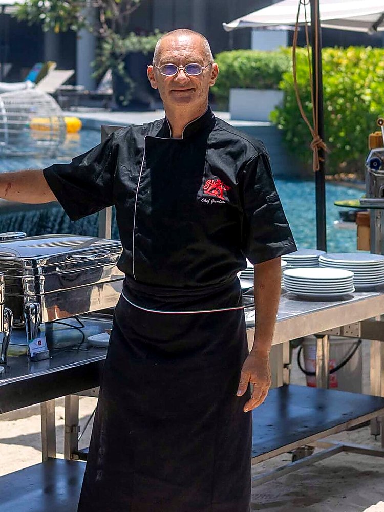 Head Chef Gianluca in his chef jacket beside the buffet at Gusto Italiano, Koh Samui